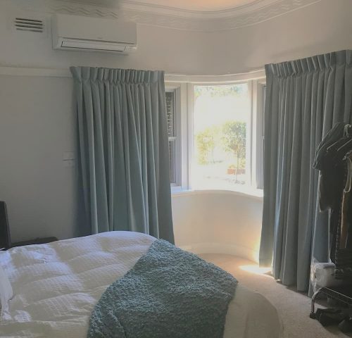 Blue Blackout Curtains Installed in Bedroom for Light Control — Winning Blinds in Cardiff, NSW Blue Blackout Curtains Installed in Bedroom for Light Control — Winning Blinds in Cardiff, NSW
